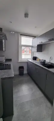 a kitchen with gray counters and a sink and a window at Polaris Apartments in Blackpool