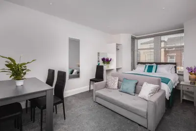 a bedroom with a bed and a table and chairs at Polaris Apartments in Blackpool