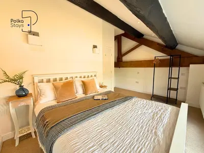 a bedroom with a large bed in a room at No 2 PolkaStays Ivy Farm Rosewood Cottage in Plumpton