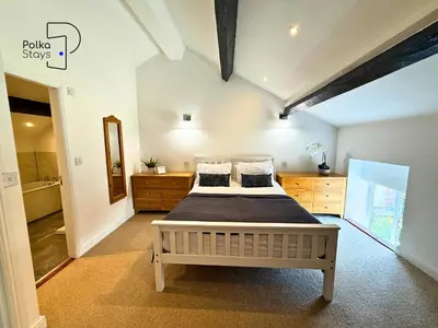 a bedroom with a large bed in a room at No 2 PolkaStays Ivy Farm Rosewood Cottage in Plumpton