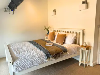 a bedroom with a white bed with pillows at No 2 PolkaStays Ivy Farm Rosewood Cottage in Plumpton