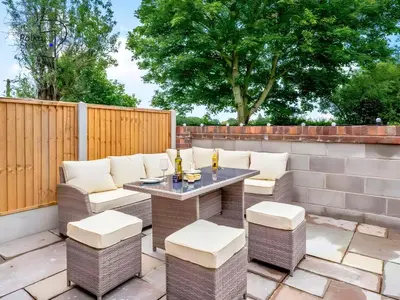 a patio with a table and chairs and a fence at No 2 PolkaStays Ivy Farm Rosewood Cottage in Plumpton