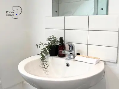 a white sink in a bathroom with a mirror at No 3 PolkaStays Ivy Farm Coach House Family Suite in Plumpton