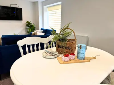 a white table with a basket and cupcakes on it at No 3 PolkaStays Ivy Farm Coach House Family Suite in Plumpton