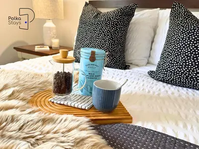 a tray with a cup of coffee on a bed at No 3 PolkaStays Ivy Farm Coach House Family Suite in Plumpton