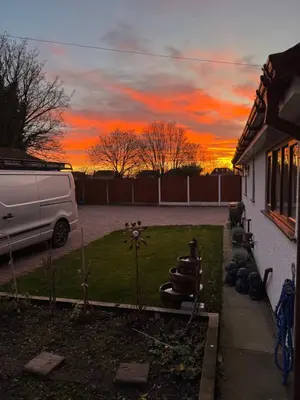 a van parked in a yard with a sunset at Beech barn in Standish