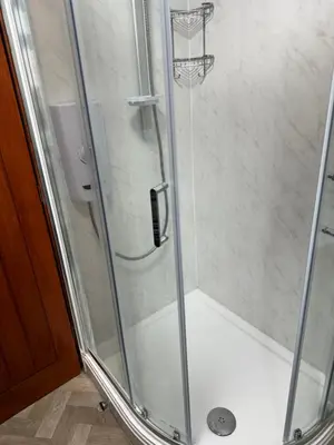 a shower stall with a glass door with a shower at Beech barn in Standish