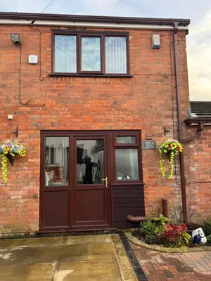a brick house with a wooden door and windows at Beech barn in Standish