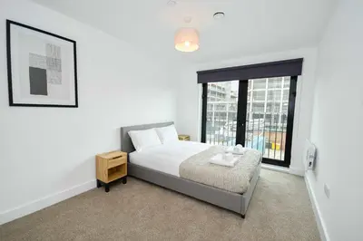 a bedroom with a bed and a large window at Modern & Spacious 2 Bedroom Liverpool Apartment in Liverpool