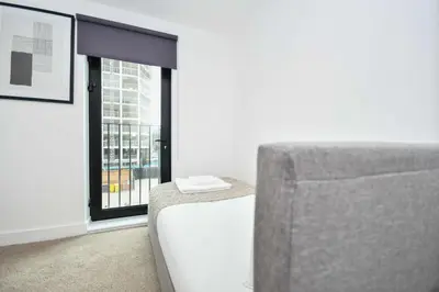 a living room with a couch and a window at Modern & Spacious 2 Bedroom Liverpool Apartment in Liverpool