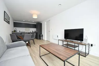 a living room with a couch and a flat screen tv at Modern & Spacious 2 Bedroom Liverpool Apartment in Liverpool