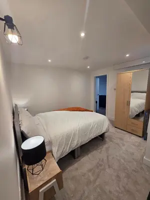 a bedroom with a bed and a table in it at Courtyard High Spec Apartment in Town Centre in Blackburn