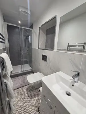 a bathroom with a sink and a toilet and a mirror at Courtyard High Spec Apartment in Town Centre in Blackburn