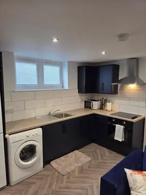 a kitchen with a sink and a washing machine at Courtyard High Spec Apartment in Town Centre in Blackburn