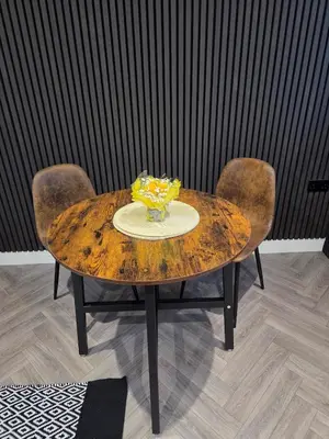 a wooden table with two chairs and a vase on it at Courtyard High Spec Apartment in Town Centre in Blackburn