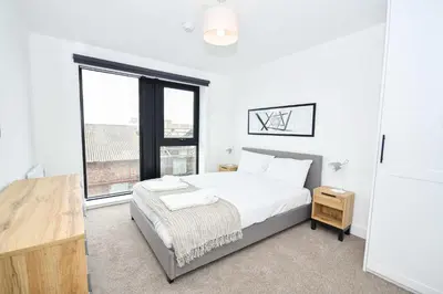 a bedroom with a bed and a large window at Bright & Spacious 2 Bed Apartment in Liverpool in Liverpool