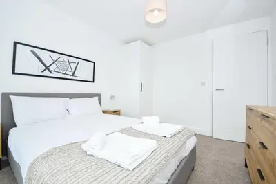 a bedroom with a white bed with two towels on it at Bright & Spacious 2 Bed Apartment in Liverpool in Liverpool