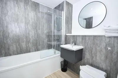 a bathroom with a tub and a sink and a mirror at Bright & Spacious 2 Bed Apartment in Liverpool in Liverpool