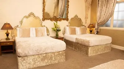 a bedroom with two beds and a mirror on the wall at White Star Line Hotel in Liverpool
