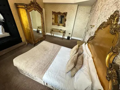 a bedroom with a large bed and a mirror at White Star Line Hotel in Liverpool