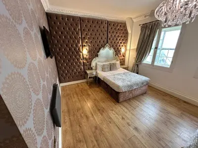 a bedroom with a bed with a large padded wall at White Star Line Hotel in Liverpool