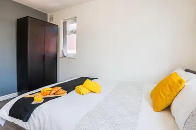 a bedroom with a white bed with yellow pillows at Contractors House with Parking City Area, sleeps 8 in Liverpool