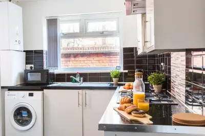 a kitchen with a counter with bread and orange juice at Contractors House with Parking City Area, sleeps 8 in Liverpool