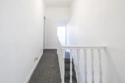 a hallway with white walls and a white staircase at Contractors House with Parking City Area, sleeps 8 in Liverpool