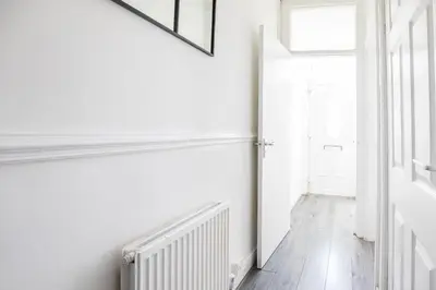 a white hallway with a radiator and a window at Contractors House with Parking City Area, sleeps 8 in Liverpool
