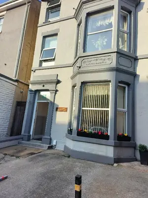 a white house with a window with flowers on it at Springfield house holiday apartments in Blackpool