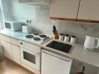 a kitchen with a stove and a microwave at Springfield house holiday apartments in Blackpool