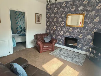 a living room with a couch and a chair and a mirror at Springfield house holiday apartments in Blackpool