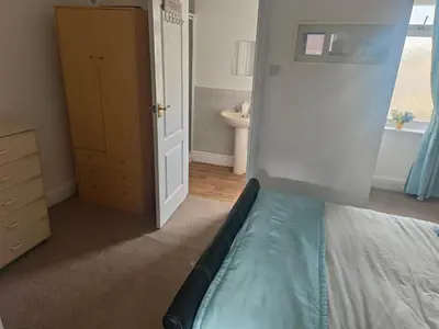 a small bedroom with a bed and a bathroom at Springfield house holiday apartments in Blackpool