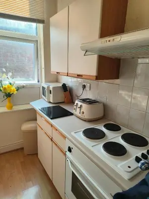 a kitchen with a white stove top oven next to a window at springfield house in Blackpool