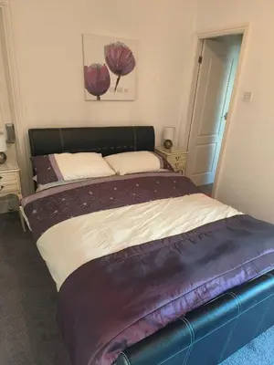 a bedroom with a large bed with purple sheets at springfield house in Blackpool