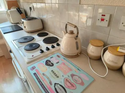 a kitchen counter with a stove with a tea kettle at springfield house in Blackpool