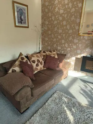 a living room with a brown couch with pillows at springfield house in Blackpool