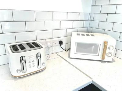 a microwave and toaster on a counter in a kitchen at Ideal 4 Bed Home sleeps 7 Nr Middlebrook Stadium in Lostock