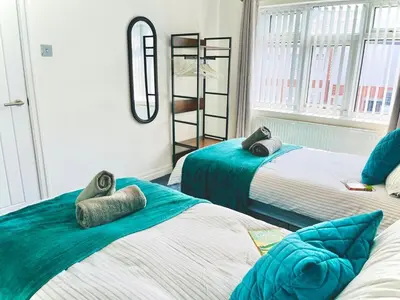 a bedroom with two beds with towels on them at Ideal 4 Bed Home sleeps 7 Nr Middlebrook Stadium in Lostock