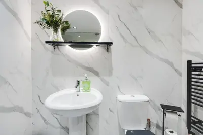 a white bathroom with a sink and a toilet at Liverpool Warehouse Flat - Sleeps 5, WiFi, Free On-Site Parking in Liverpool