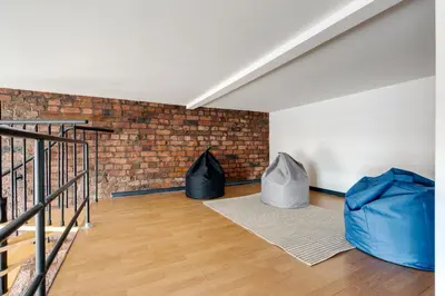 a room with two bags on the floor and a brick wall at Liverpool Warehouse Flat - Sleeps 5, WiFi, Free On-Site Parking in Liverpool