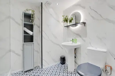 a white bathroom with a sink and a toilet at Liverpool Warehouse Flat - Sleeps 5, WiFi, Free On-Site Parking in Liverpool
