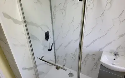 a shower with a glass door next to a sink at Sure stay property in Bolton