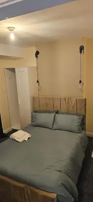 a bed in a room with two lights above it at Sure stay property in Bolton