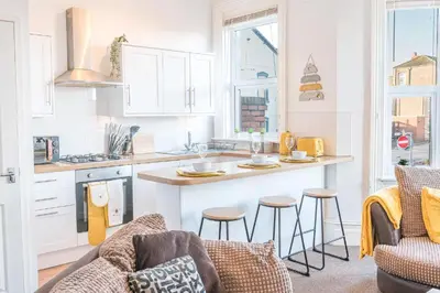 a kitchen with a couch and a counter in a kitchen at Cozy & Modern Accommodation in Barrow-in-Furness in Barrow in Furness