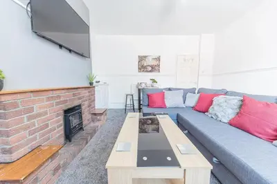 a living room with a blue couch and a fireplace at Cozy & Modern Accommodation in Barrow-in-Furness in Barrow in Furness