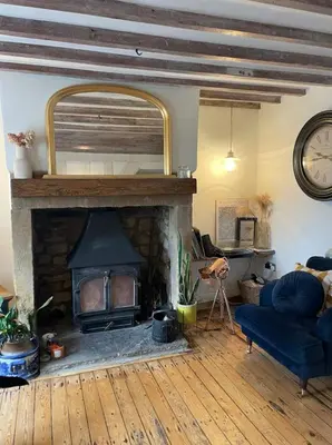 a living room with a fireplace and a blue couch at Squirrel Cottage in Ribchester