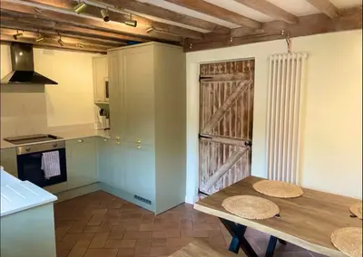 a kitchen with a wooden table and a wooden door at Squirrel Cottage in Ribchester