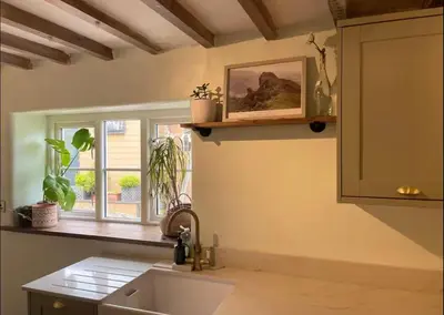 a kitchen with a sink and a window with plants at Squirrel Cottage in Ribchester