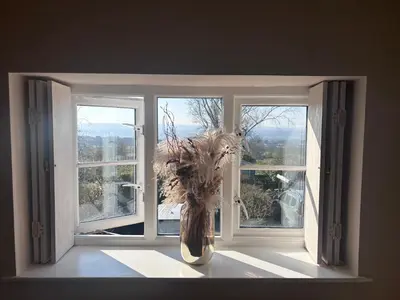 a vase with a plant sitting in a window at Squirrel Cottage in Ribchester